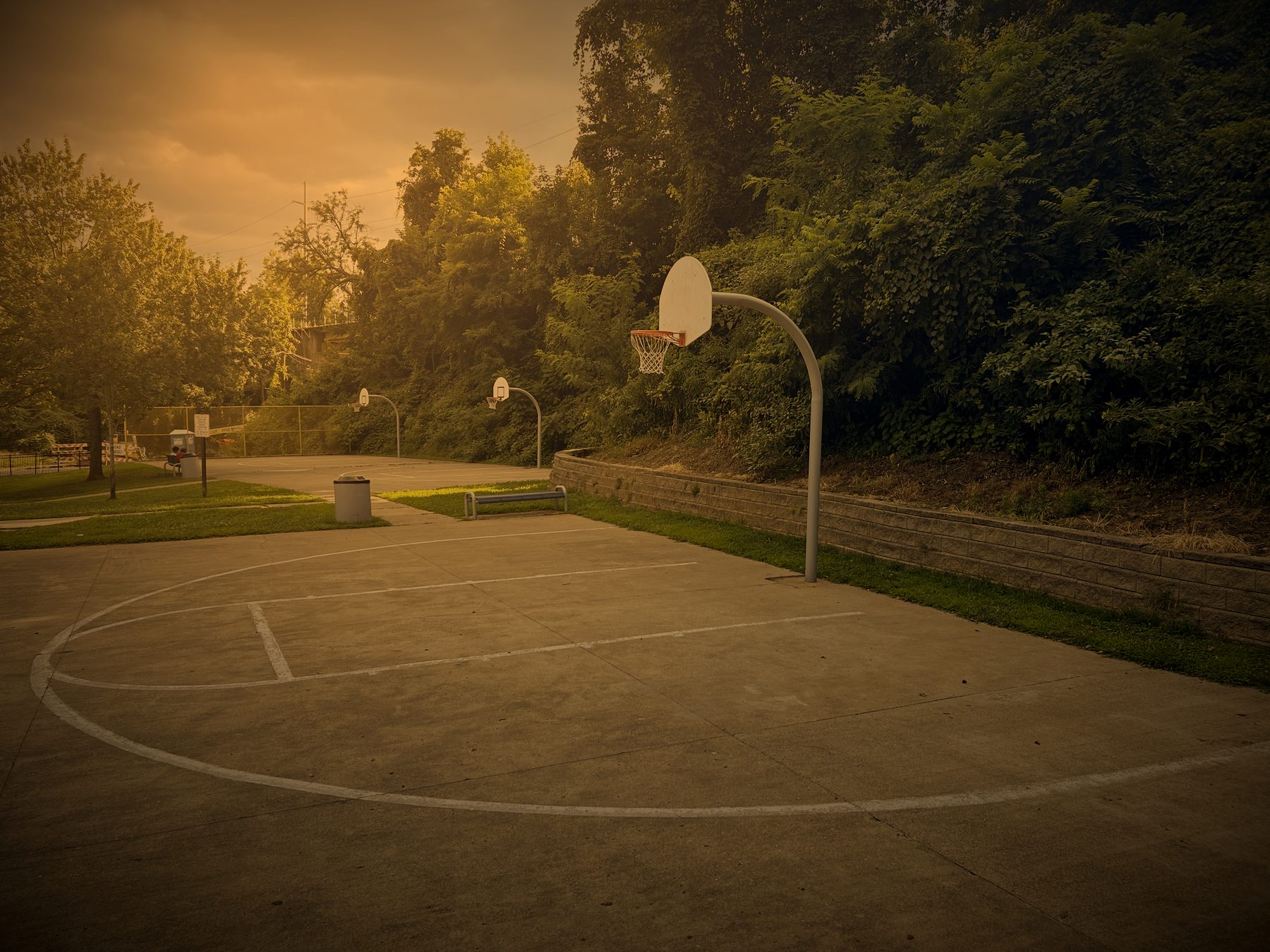 Two outdoor courts and a bench at Swope