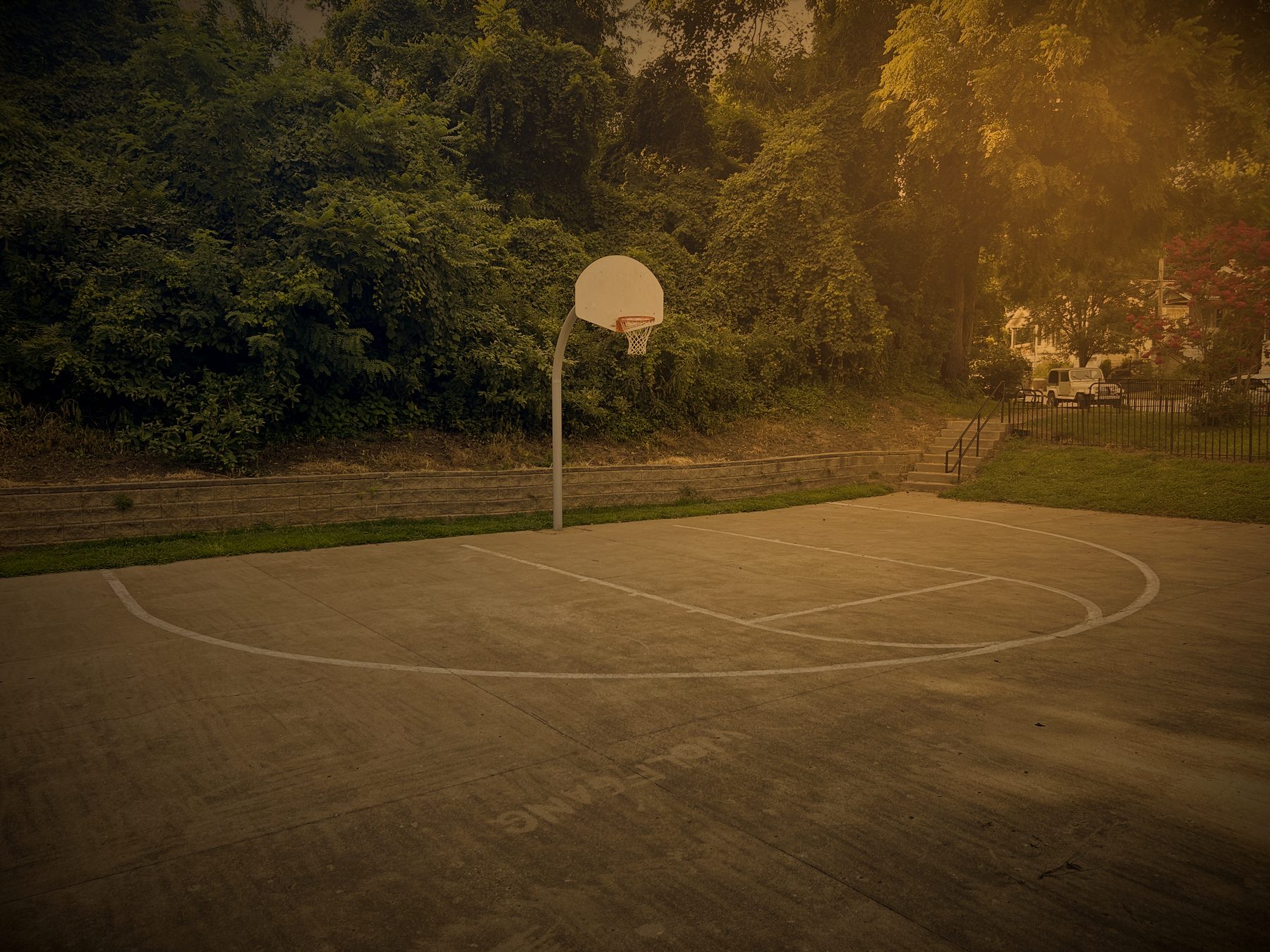 Outdoor concrete basketball court at Swope in late evening light